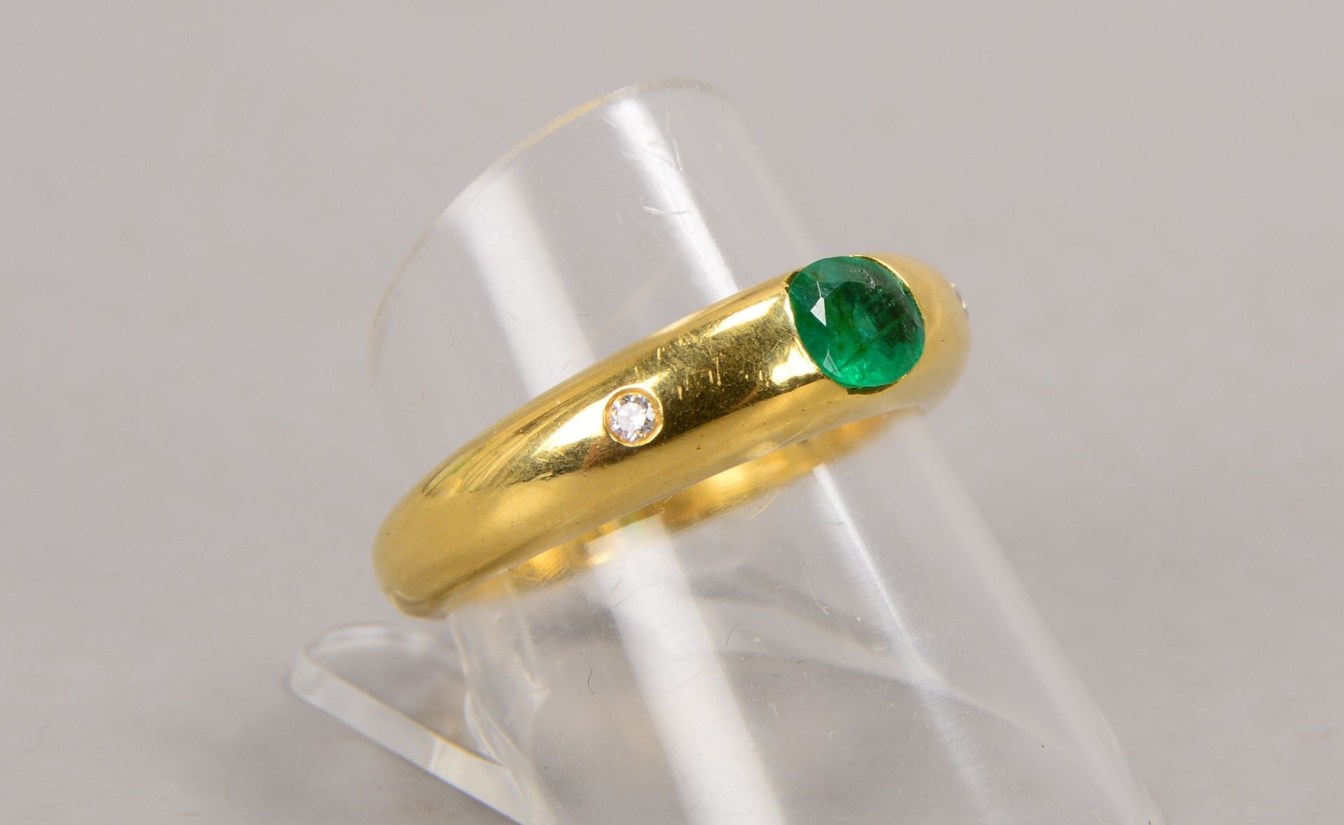 Ring, 759 GG (gestempelt), besetzt mit einzelnem Smaragd, sowie mit 2-fachem Brillantbesatz