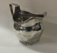 A Georgian silver cream jug of plain form on ball