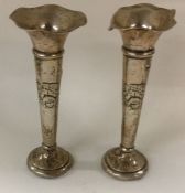 A pair of silver vases decorated with cherubs.