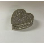 A silver heart shaped box with chased decoration. Approx. 56