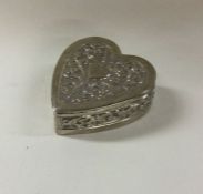 A silver heart shaped box with chased decoration. Approx. 56