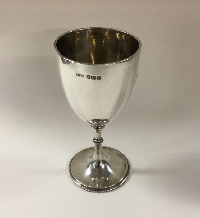 A silver goblet with beaded border on pedestal foo