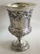 A heavy cast silver goblet profusely decorated wit