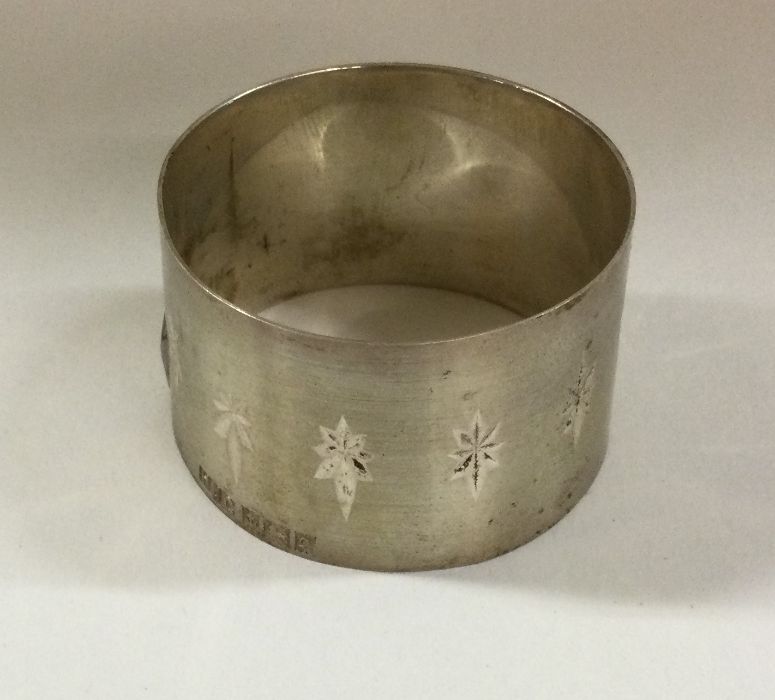 An unusual silver napkin ring with star decoration