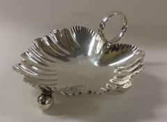 A Victorian silver shell dish on ball feet. London