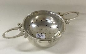 A silver matching tea strainer on stand. London 19