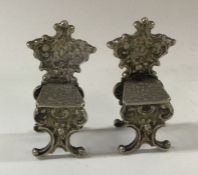 A pair of miniature silver toy chairs bearing impo