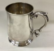 A George II silver mug decorated with armorial.