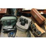 A collection of old cameras and binoculars.