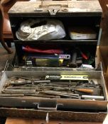 An old tin trunk containing tools and accessories.