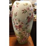 A tall Moorcroft vase decorated with spring flowers.
