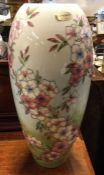 A tall Moorcroft vase decorated with spring flowers.