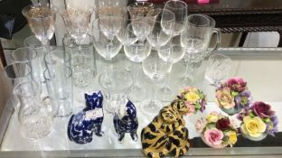 A collection of wine glasses, pottery cats etc.