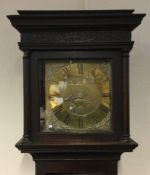 An oak cased and brass faced grandfather clock.