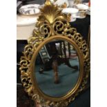 A large oval gilt framed mirror.