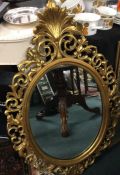 A large oval gilt framed mirror.