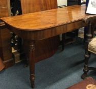 A Victorian mahogany table with fluted supports.