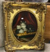 A rectangular gilt framed picture of cats.