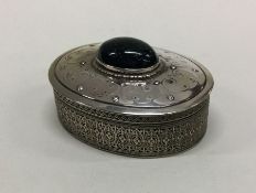 A silver hinged box with stone to centre and pierc