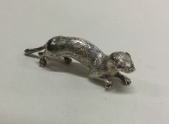 A heavy cast figure of an ferret with textured bod