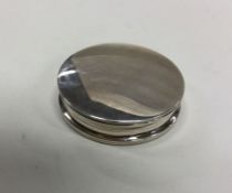 A large heavy circular silver box with lift-off co