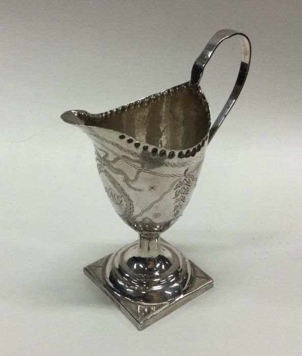 A George III silver cream jug with floral decorati