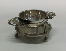 A heavy Edwardian silver tea strainer on matching