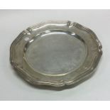 A large circular silver dinner plate with reeded r