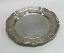 A large circular silver dinner plate with reeded r