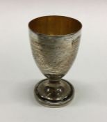 A Victorian silver engraved egg cup. London 1894.