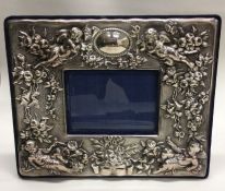 An unusual silver picture frame with chased angel