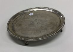 A Georgian silver teapot stand with crested centre