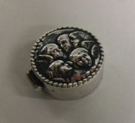 A silver hinged box with cherub decoration. Approx