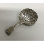 A silver caddy spoon with engraved handle and chas