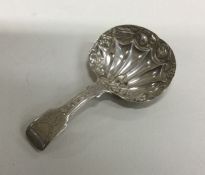 A silver caddy spoon with engraved handle and chas