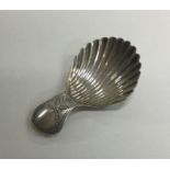 A silver engraved caddy spoon with floral decorati
