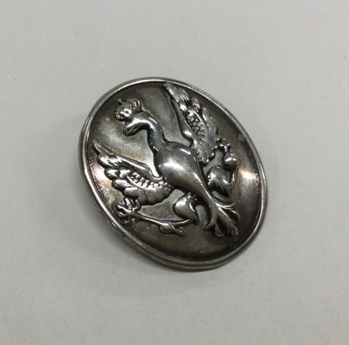 An oval silver badge with shield decoration. Birmi