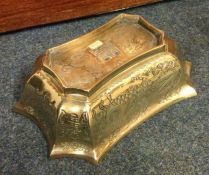 A heavy shaped brass Chinese bowl decorated with w