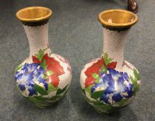 A pair of cloisonné vases decorated in bright colo