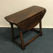 An oak two flap occasional table. Est. £20 - £30.