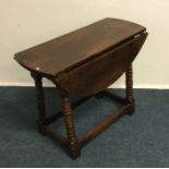 An oak two flap occasional table. Est. £20 - £30.