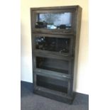 A metal and glass four section bookcase. Est. £100