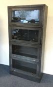 A metal and glass four section bookcase. Est. £100