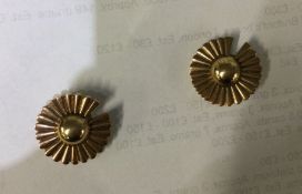 A small pair of gold earrings of floral design. Ap