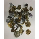 A quantity of brass and other Military cap badges.