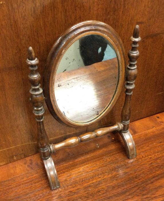 An Antique mahogany mirror of oval form. Est. £10