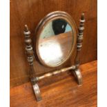 An Antique mahogany mirror of oval form. Est. £10