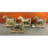 A set of four hard stone horses on matching bases.