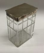 A large silver and glass engine turned toilet box. London 1914. By Mappin and Webb. Est. £30 - £40.