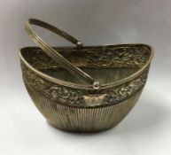 An Edwardian silver swing handled sugar basket wit